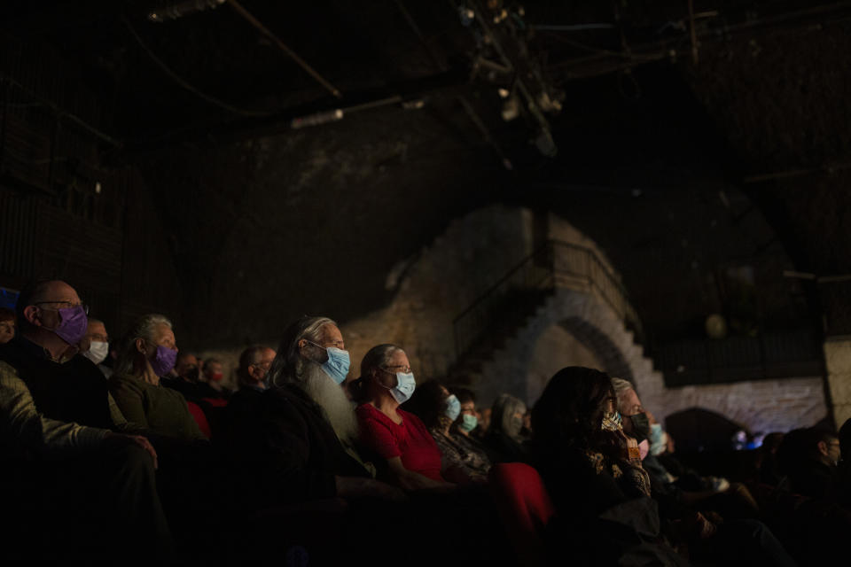 The audience wearing protective face masks watches on opening night at the Khan Theater during a performance where all guests were required to show proof of receiving a COVID-19 vaccination or full recovery from the virus, in Jerusalem, Tuesday, Feb. 23, 2021. (AP Photo/Maya Alleruzzo)