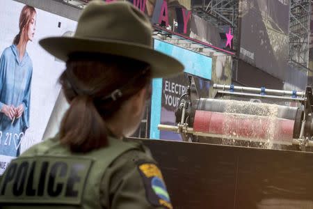 A New York State Department of Environmental Conservation enforcement officer watches as crushed pieces of confiscated Ivory are loaded into a truck in New York's Times Square June 19, 2015. REUTERS/Brendan McDermid