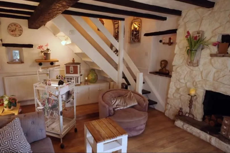 The living room at the property featured a statement corner staircase, stone walls and traditional beams