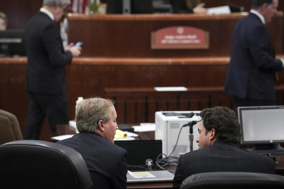 Texas Attorney General Ken Paxton, front left, talks with his defense attorney Anthony Osso, Jr., during a hearing in his securities fraud case , Friday, Feb. 16, 2024, at the Harris County criminal courthouse in Houston. A judge on Friday rejected Paxton’s attempts to throw out felony securities fraud charges that have shadowed the Republican for nearly a decade. (Jon Shapley/Houston Chronicle via AP)