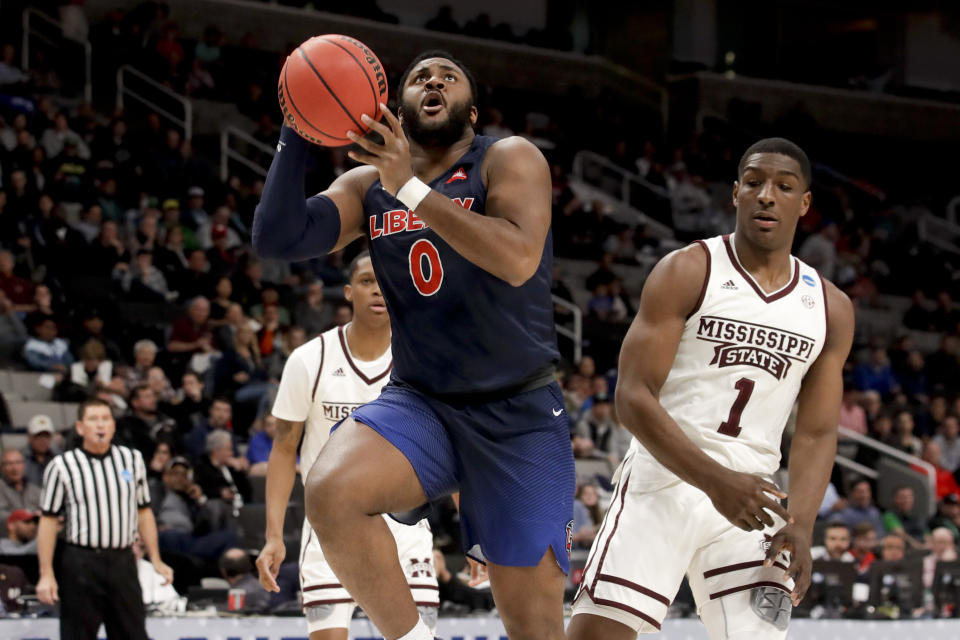 Liberty forward Myo Baxter-Bell, left, drives to the basket past Mississippi State forward Reggie Perry during the first half of a first-round men's college basketball game in the NCAA Tournament on Friday, March 22, 2019, in San Jose, Calif. (AP Photo/Jeff Chiu)