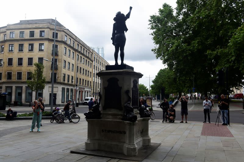 People take pictures of the sculpture of a Black Lives Matter protester standing on the empty plinth previously occupied by the statue of slave trader Edward Colston, in Bristol