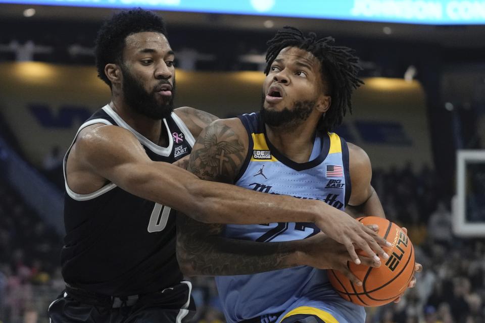 Marquette's Sean Jones is fouled by Georgetown's Dontrez Styles during the first half of an NCAA college basketball game Friday, Dec. 22, 2023, in Milwaukee. (AP Photo/Morry Gash)