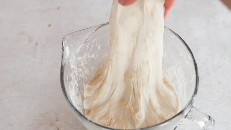 hand pulling sourdough in glass bowl