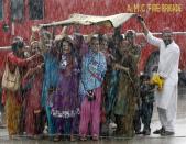 Relatives of Haj pilgrims wave in the rain, as they see off their relatives who are leaving Ahmedabad for Mecca in Saudi Arabia to take part in the annual religious Haj pilgrimage, September 26, 2013. REUTERS/Amit Dave