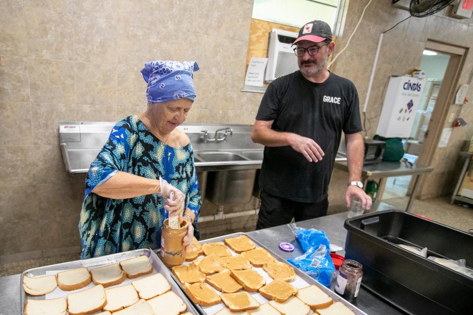 Volunteer Elizabeth McCulloch and Mark Watson make peanut butter and jelly sandwiches as the Grace Marketplace Street Team prepares to deliver drinks and sandwiches to homeless people in Northwest Gainesville on Aug. 14, 2023.