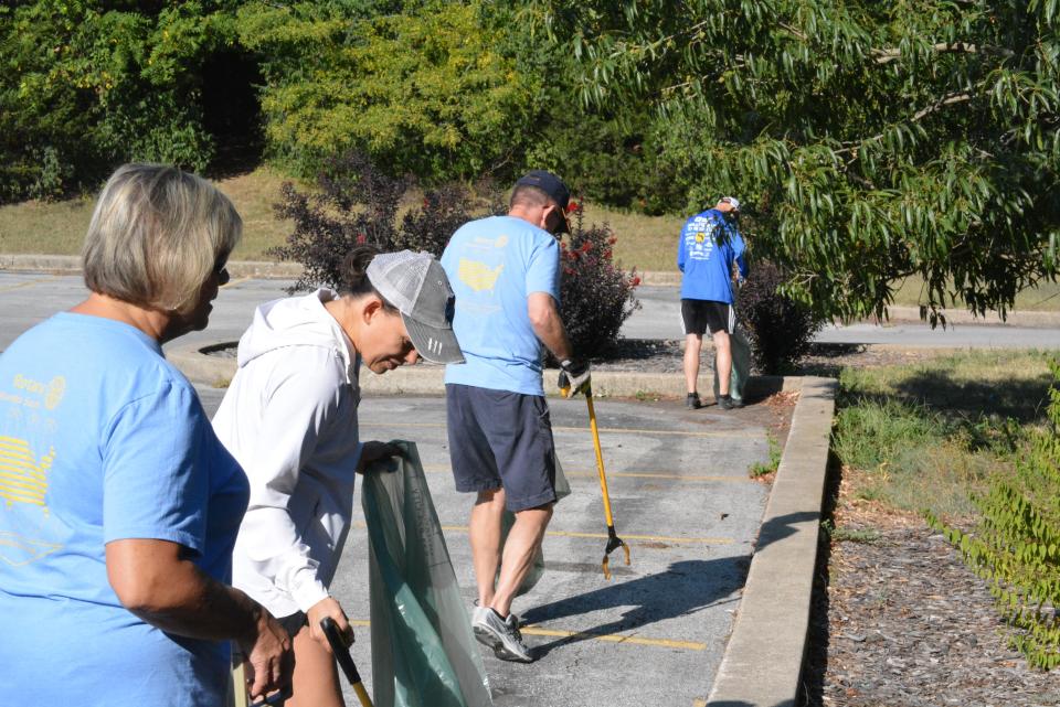 Jackie Reed, Teresa Gooch, Dell Epperson and Chad Gooch with the Columbia South Rotary Club search for trash Saturday near the skate park in Cosmo Park as part of cleanup efforts by Columbia service clubs. 