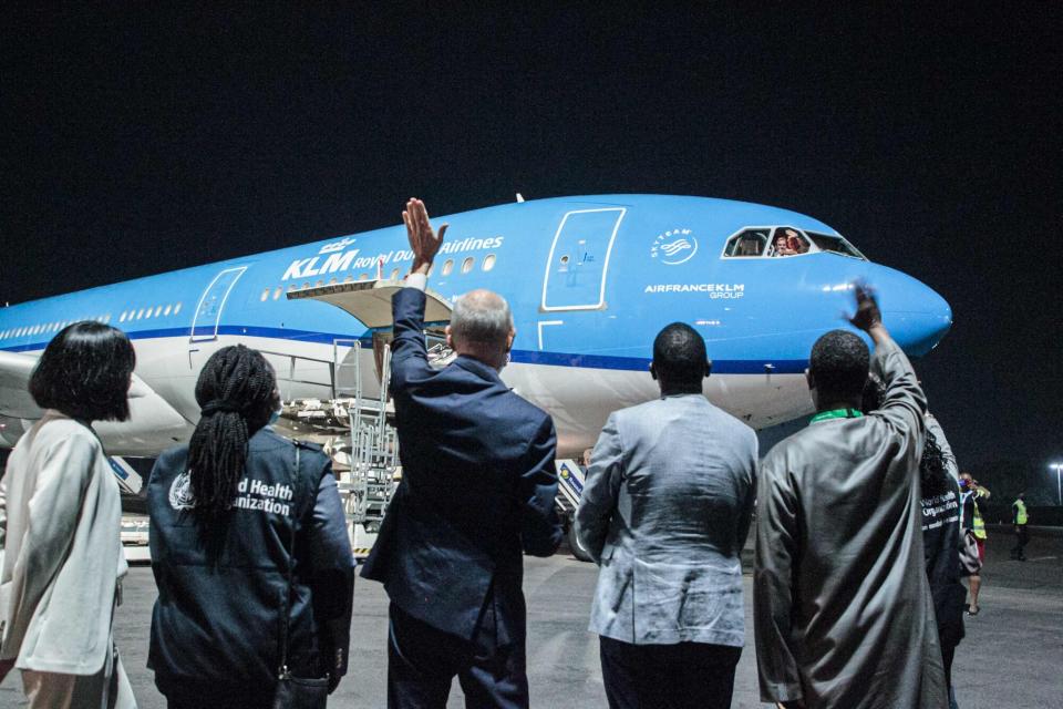 RUANDA - El embajador holandés en Ruanda Matthijs Clemens Wolters y el Representante de la ONU en Ruanda Fodey Ndiaye saludan a los pilotos de KLM sobre la llegada del primer lote de 102,960 dosis de vacunas de coronavirus Pfizer-BioNTech Covid-19 en el Aeropuerto Internacional de Kigali en Kigali, Ruanda, el 3 de marzo de 2021. Ruanda se convirtió en el primer país africano en recibir la vacuna contra el coronavirus de Pfizer-BioNTech, con alrededor de 100,000 dosis administradas en lo que el gigante farmacéutico aclamó como un "hito" para la continente.