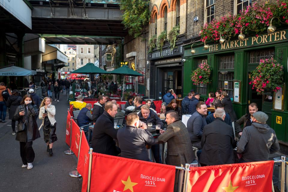 After-work drinkers enjoy a pint outside The Market Porter pub in Borough Market, in London on September 25, 2020, as new earlier closing times for pubs and bars in England and Wales are introduced to combat the spread of the coronavirus. - Britain has tightened restrictions to stem a surge of coronavirus cases, ordering pubs to close early and advising people to go back to working from home to prevent a second national lockdown. (Photo by Tolga AKMEN / AFP) (Photo by TOLGA AKMEN/AFP via Getty Images)