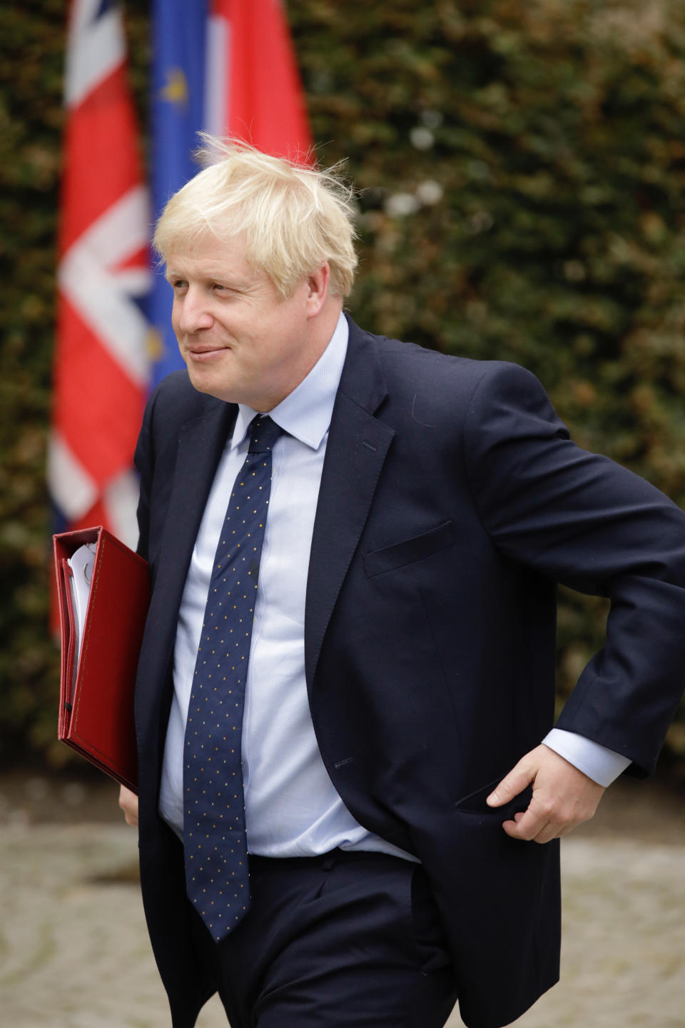British Prime Minister Boris Johnson walks by flags after a meeting with Luxembourg's Prime Minister Xavier Bettel at the prime ministers office in Luxembourg, Monday, Sept. 16, 2019. (AP Photo/Olivier Matthys)