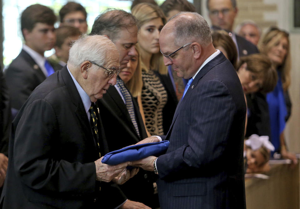 Louisiana Governor John Bel Edwards presents the folded state flag from her casket to her husband Raymond during a Celebration of Life Interfaith Service for former Louisiana Gov. Kathleen Babineaux Blanco, at St. Joseph Cathedral in Baton Rouge, La., Thursday, Aug. 22, 2019. Thursday was the first of three days of public events to honor Blanco, the state's first female governor who died after a years long struggle with cancer.(AP Photo/Michael Democker, Pool)