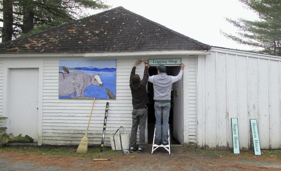 In this Oct. 16, 2013 photo released by Sterling College, student Weylin Garnett, left, of Corinth, N.Y., and college President Matthew Derr install a new sign on the Logging Shop during the Fall 2013 All-College Work Day at the college in Craftsbury, Vt. At Sterling and six other schools across the country are required to work as part of their education, which gives them a discount on their tuition, and some leave school debt-free. (AP Photo/Sterling College, Christian Feuerstein)