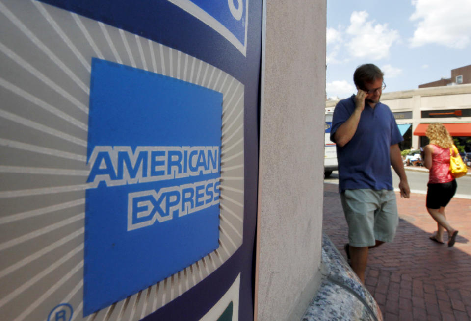 Passers-by walk past the American Express logo near the entrance of a bank in the Harvard Square neighborhood of Cambridge, Massachusetts (Courtesy Stephen Senne, Associated Press)