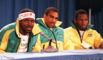 <p>Jamaica’s Frederick Powell speaks during a press conference as his teammates Michael White and Allen Caswell listen on the eve of the opening of the 1988 Winter Olympic Games in Calgary. (Getty Images) </p>