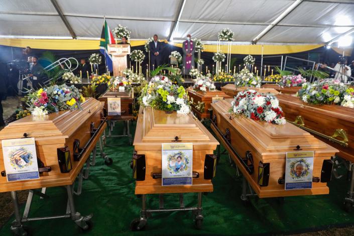 Portraits of some teenagers are seen on empty coffins during symbolic mass memorial service in East London on July 6, 2022, after 21 people died in unclear circumstances at a township tavern last month, in an incident that shocked South Africa. / Credit: PHILL MAGAKOE/AFP via Getty Images