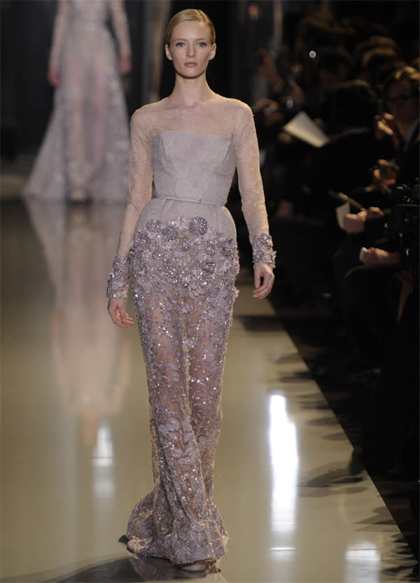 <b>Elie Saab SS13 </b><br><br>An unusual purple-tinged grey was seen throughout the collection, with the same sheer and lace fabrics, making an appearance, as well as textured jewelling around the cuffs and skirt.<br><br>©Rex