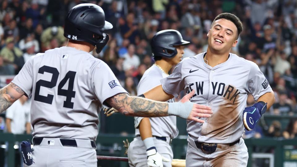 El campocorto de los Yankees de Nueva York, Anthony Volpe (derecha), celebra con sus compañeros de equipo después de anotar contra los Diamondbacks de Arizona en la tercera entrada en Chase Field.