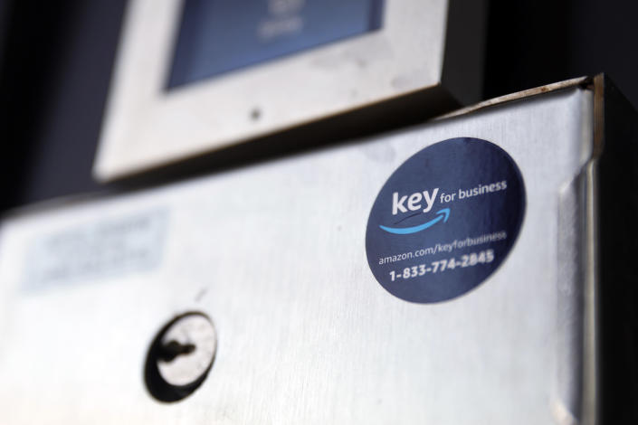 A blue sticker with the Amazon logo is displayed on a buzzer system in the apartment building of Jason Goldberg, chief commerce strategy officer at marketing company Publicis Communications, Monday, March 29, 2021, in Chicago. Amazon is making a push to install a device on buzzer systems in apartment buildings throughout the country that allows its delivery drivers to whip out a phone, tap a button and unlock a building's front doors whenever they need to leave packages in the lobby instead of the street. (AP Photo/Shafkat Anowar)