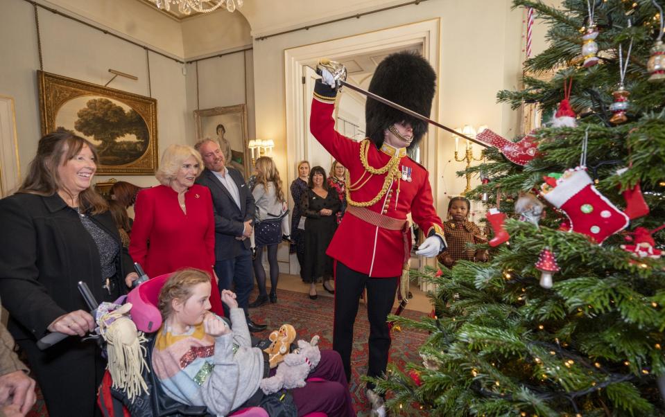 An equerry in bearskin and full Guards uniform used the tip of his sword to lift decorations onto the tree - Getty Images Europe