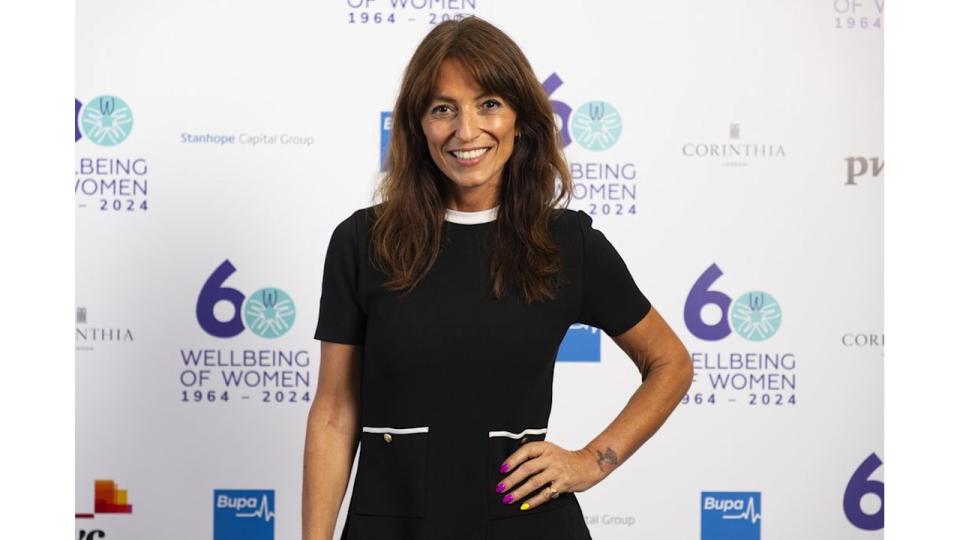 Davina McCall smiling in a black mini dress