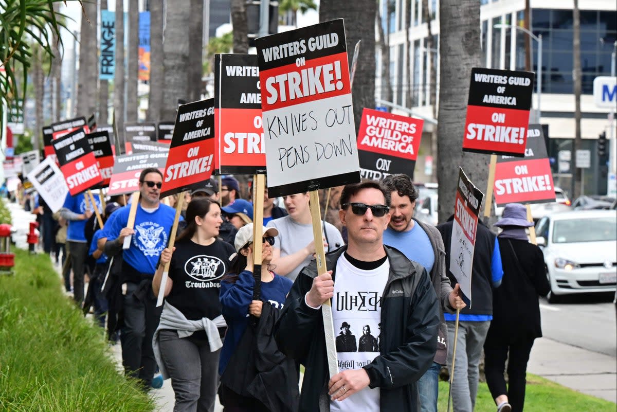 Writer Eric Heisserer holds his sign on the picket line in front of Netflix in Hollywood (Frederic J Brown / AFP via Getty Images)