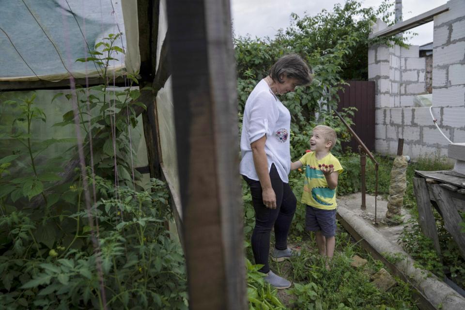 A woman and a boy in a garden.