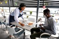 Melanie Igbe, head chef at Cafe de Elyon, attends to a customer at the cafe in Lekki, Lagos