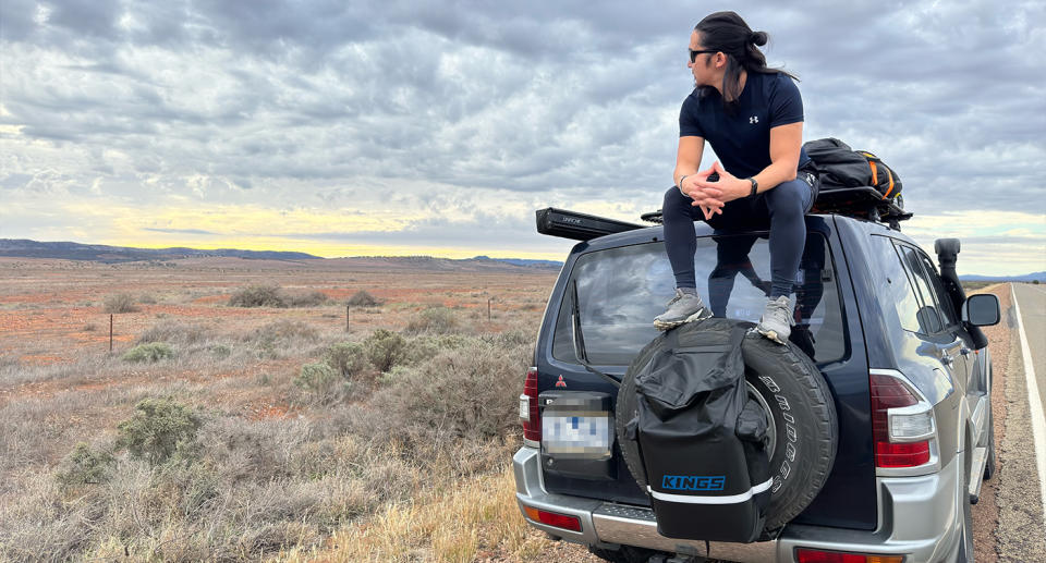 Thiago sitting on top of the 4WD in rural Australia.