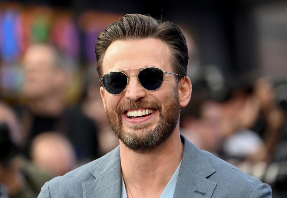 Chris at a red carpet event wearing sunglasses and smiling