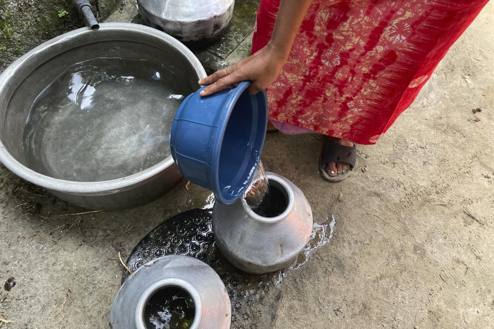 Water is transferred from tubs to small pots by residents in the Chellanam area of Kochi, Kerala state, India, on March 1, 2023. Saltwater's intrusion into freshwater is a growing problem linked to climate change and in Chellanam rising salinity means residents can no longer depend on ponds and wells for the water they need to drink, cook and wash. (Uzmi Athar/Press Trust of India via AP)