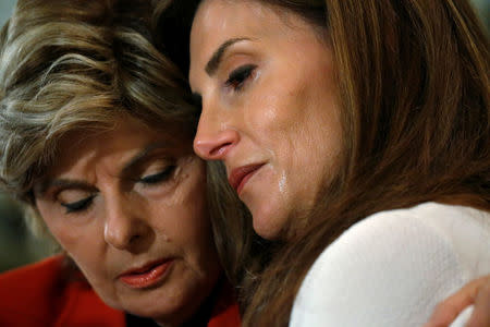 Lawyer Gloria Allred (L) hugs crying Karena Virginia, who claimed to be the victim of sexual assault by Republican presidential candidate Trump back in 1998, during a news conference in the Manhattan borough of New York, U.S., October 20, 2016. REUTERS/Carlo Allegri