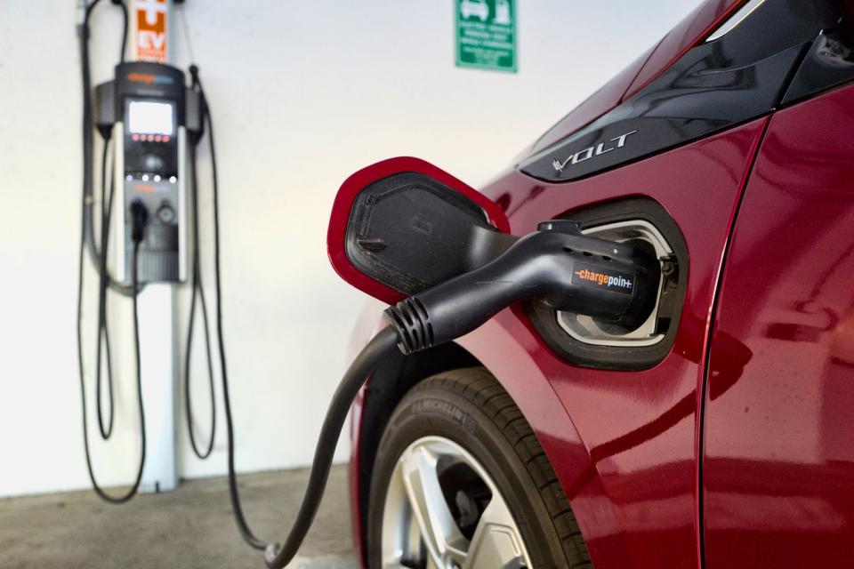 A hybrid car charges at a charging station at a parking garage in Los Angeles.