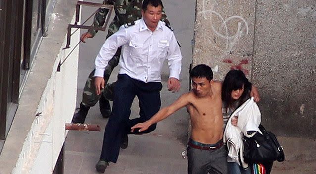 Policemen (top) run to catch a topless man holding his girlfriend hostage in Sanya. Photo: Reuters.