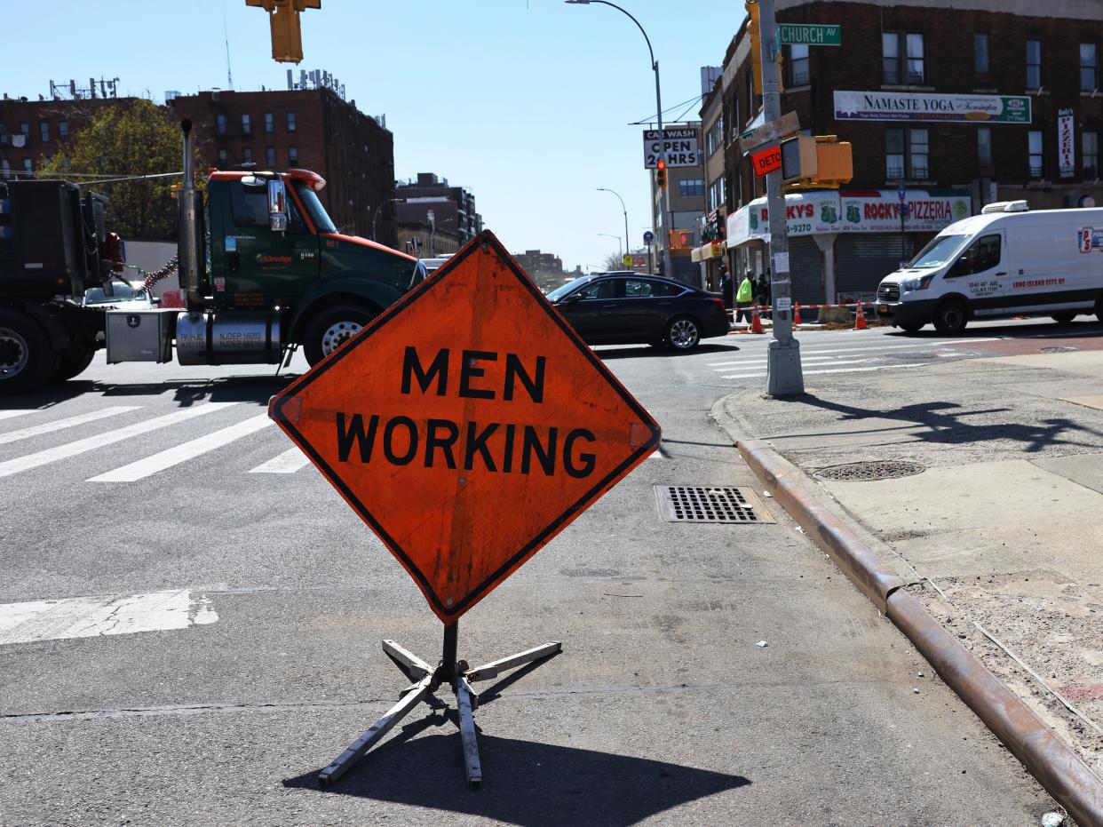 <p>A ‘Men Working’ sign is seen on the site of infrastructure repairs on the intersection of Church Avenue and Coney Island Avenue in the Flatbush neighborhood of Brooklyn borough on 6 April, 2021</p> (Getty Images)