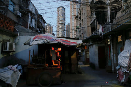 Woman surnamed Xu watches TV at her eight-square-meter house where she lives with her husband at Guangfuli neighbourhood in Shanghai, China, April 19, 2016. REUTERS/Aly Song