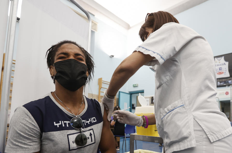 Freestyle wrestler Fatoumata Yarie Camara, of Guinea, receives the COVID-19 vaccine at the Santo Spirito hospital in Rome, Saturday, July 3, 2021. A West African wrestler's dream of competing in the Olympics has come down to a plane ticket. Fatoumata Yarie Camara is the only Guinean athlete to qualify for these Games. She was ready for Tokyo, but confusion over travel reigned for weeks. The 25-year-old and her family can't afford it. Guinean officials promised a ticket, but at the last minute announced a withdrawal from the Olympics over COVID-19 concerns. Under international pressure, Guinea reversed its decision. (AP Photo/Riccardo De Luca)