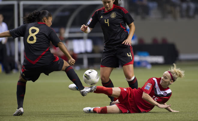 VANCOUVER, CANADA - JANUARY 27: Kelly Parker #15 of Canada tries to play the ball after falling when challenged by Marylin Diaz #8 of Mexico during the first half of semifinals action of the 2012 CONCACAF Women's Olympic Qualifying Tournament at BC Place on January 27, 2012 in Vancouver, British Columbia, Canada. (Photo by Rich Lam/Getty Images)