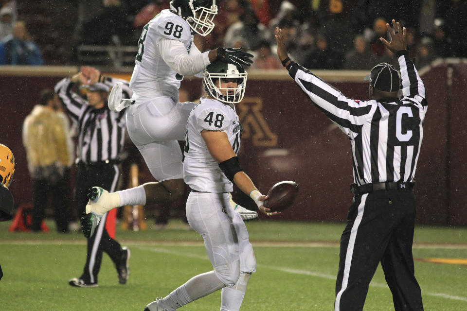 Michigan State Kenny Willekes (48) tosses the ball to an official after recovering a fumble as teammate Demetrius Cooper (98) comes in to celebrate, Saturday, Oct. 14, 2017, in Minneapolis. (AP Photo/Andy Clayton-King)