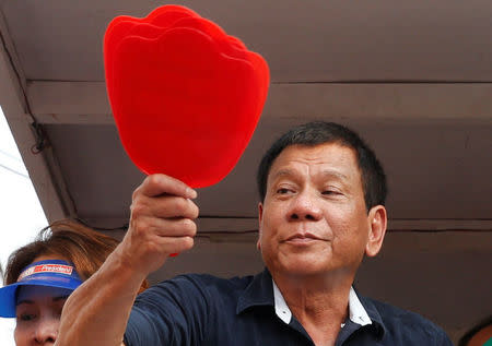 Presidential candidate Rodrigo "Digong" Duterte holds election souvenir fans for his supporters during election campaigning in Malabon, Metro Manila in the Philippines April 27, 2016. REUTERS/Erik De Castro