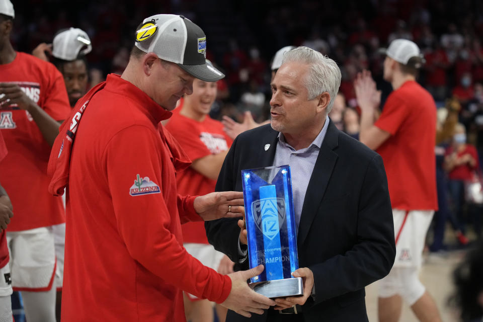 Arizona head coach Tommy Lloyd receives the Pac-12 Conference Championship trophy from Deputy Commissioner and COO Jamie Zaninovich after an NCAA college basketball game against California, Saturday, March 5, 2022, in Tucson, Ariz. (AP Photo/Rick Scuteri)