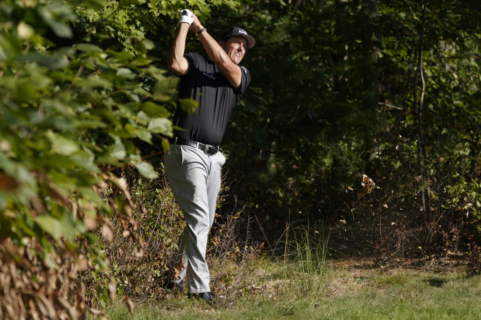 Phil Mickelson watches his shot out of the woods and onto the 14th green during the second round of the Northern Trust golf tournament at TPC Boston, Friday, Aug. 21, 2020, in Norton, Mass. (AP Photo/Charles Krupa)