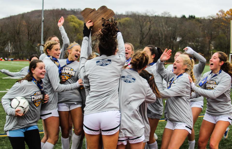 Rye raises up the state championship plaque following its 2-0 win over Shoreham-Wading River during the NYSPHSAA Class A girls soccer state championship match at Cortland High School on Sunday, Nov. 12, 2023.