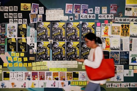 A woman walks past a Lennon Wall placed by anti-government protesters to commemorate the fifth anniversary of the Umbrella Movement, in Hong Kong