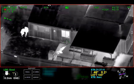 Stephon Clark, 22, is visible on the ground after two police officers (L) shot him, in this still image captured from police aerial video footage released by Sacramento Police Department, California, U.S., on March 21, 2018. Courtesy Sacramento Police Department/Handout via REUTERS