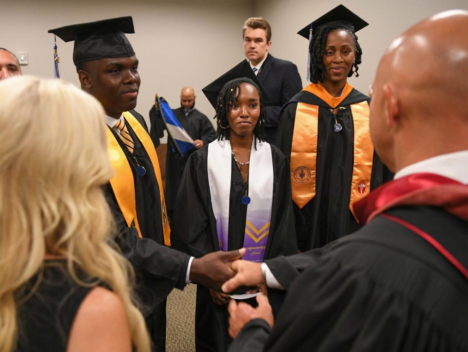 Gabriel McMinn (from left) and his sisters-in-law Charlene and Natasha Le Gendre meet U.S. Rep. Brian Mast before the three graduated from Keiser University during the college's commencement ceremony at Westside Church on Friday, June 2, 2023, in Fort Pierce. All three were awarded their degrees: Gabriel, Associate of Science in Nursing; Charlene, Associate of Science in Graphic Art and Design; and Natasha, Master of Science in Nursing.