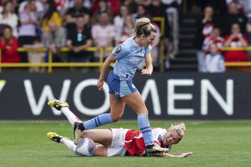 Manchester City's Lauren Hemp, foreground and Arsenal's Alessia Russo battle for the ball, during the Women's Super League soccer match between Manchester City and Arsenal, at the Joie Stadium, in Manchester, England, Sunday May 5, 2024. (Martin Rickett/PA via AP)