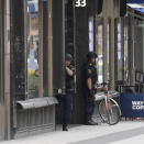 Police officers stand in a doorway at the scene after a truck crashed into a department store injuring several people in central Stockholm, Sweden, Friday April 7, 2017. (Anders Wiklund TT News Agency via AP)