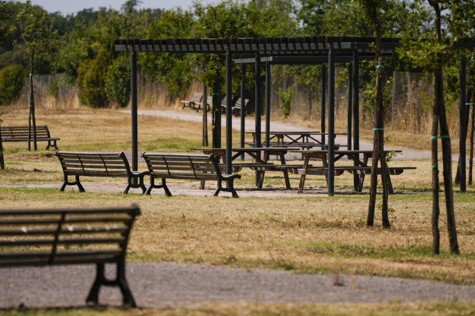 Empty benches and picnic areas are seen in a sun-burnt park in Rome, Italy, Thursday, July 20, 2023. An intense heat wave has reached Italy, bringing temperatures close to 40 degrees Celsius (104 F) in many cities across the country. (AP Photo/Andrew Medichini)