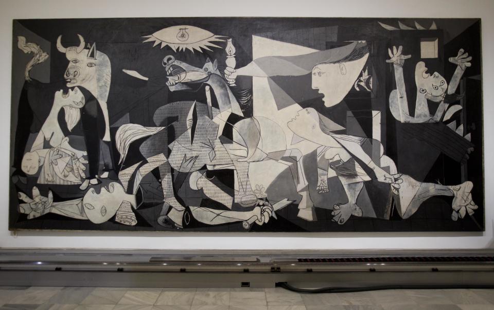 FILE - This Feb. 21, 2012 file photo shows Pablo Picasso's "Guernica" painting displayed at the Reina Sofia Museum in Madrid. The museum was one of a number of places visited by Raf Casert on a father-son trip to the city with his teenage son. (AP Photo/Paul White, file)