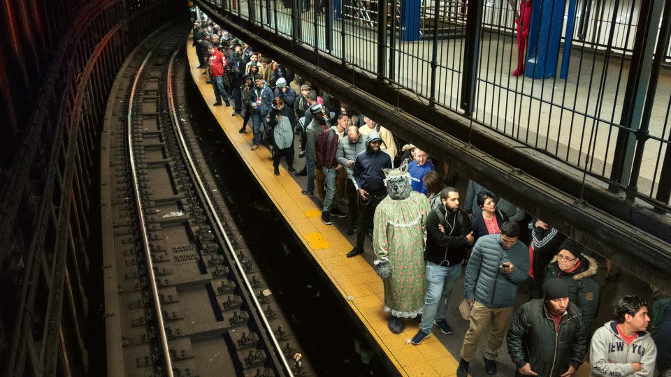 Grandma Wolf waits on the platform — not the best person to ask "what's the time?" of the next 4 train's arrival. - Seymour Licht